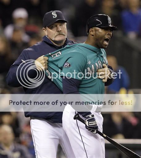 Seattle manager Eric Wedge pulls Milton Bradley away from umpire Mike Muchlinski after Bradley was called out on strikes on Friday in Seattle. Bradley was ejected. (AP)